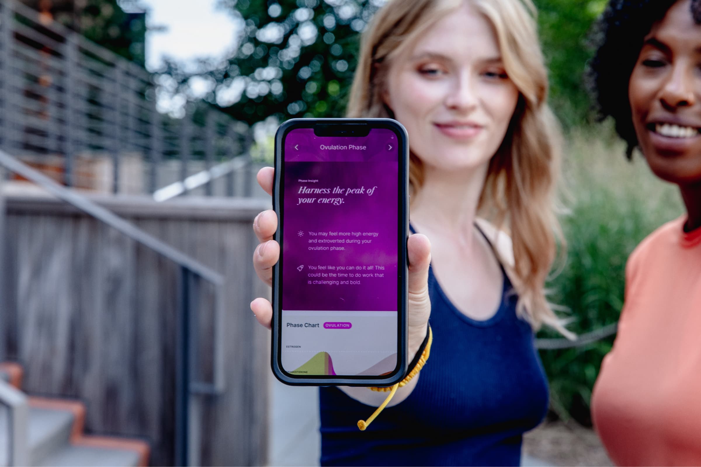 Image of a woman holding a phone showing the Embody app